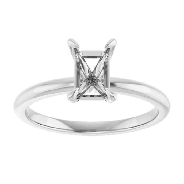 This solitaire ring mounting is designed to hold a 7x5 mm emerald-cut center stone, showcasing clean geometry and timeless elegance. The sharp lines and elongated shape of the emerald cut highlight the ring’s modern minimalist structure. Although understated, the design draws attention with its symmetry and balance. Moreover, its proportion fits comfortably on the finger, making it a versatile base for lab-grown or natural stones.
