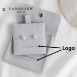 Custom microfiber suede jewelry packaging with logo customization. Available in pink, gray, and gray blue. Soft suede-like texture, durable, 100pcs MOQ.