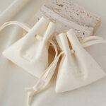 Custom microfiber ingot pouch made from light-colored soft suede. It is designed for jewelry brands seeking unique, professional, and protective packaging solutions with a 100-piece MOQ.