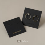 This custom black jewelry card features a rigid paperboard structure and precise cut-outs. It provides a professional display solution for jewelry.