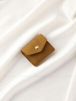 This custom folding jewelry pouch features a snap button and organized interior. It provides an elegant storage solution for jewelry branding.