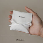 This custom white cotton pouch features a clean design and a soft drawstring closure. It provides an organic storage solution for jewelry branding.