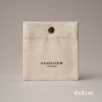 The design features a classic rectangular silhouette. It includes a reinforced snap button closure. Therefore, the jewelry stays in place without any risk of slipping out. The cotton canvas material is selected for its breathability. Additionally, the soft inner surface helps prevent scratches on delicate metal finishes. Its compact size makes it an ideal companion for travel. Moreover, it maintains a professional appearance that aligns with modern branding standards. The tactile experience of the canvas adds a layer of quality to your presentation.