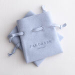 This custom microfiber ingot pouch features a unique ingot shape. It provides a soft, elegant, and secure storage solution for professional jewelry branding with a 100pc MOQ.