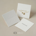 This custom white jewelry card features a soft cotton-textured structure and precise cut-outs. It provides a professional display solution for jewelry.