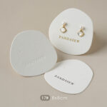 This custom white jewelry card features a soft cotton-textured structure and precise cut-outs. It provides a professional display solution for jewelry.