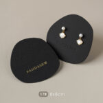 This custom black jewelry card features a rigid paperboard structure and precise cut-outs. It provides a professional display solution for jewelry.