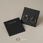 This custom black jewelry card features a rigid paperboard structure and precise cut-outs. It provides a professional display solution for jewelry.