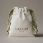 The pouch features a soft yet structured format that keeps jewelry protected during storage and transport. Its natural texture enhances visual warmth without overwhelming the overall presentation. The design remains understated, allowing the jewelry itself to remain the center of attention. This format is suitable for both daily retail use and e-commerce shipping environments.