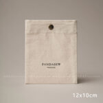 The design features a classic rectangular silhouette. It includes a reinforced snap button closure. Therefore, the jewelry stays in place without any risk of slipping out. The cotton canvas material is selected for its breathability. Additionally, the soft inner surface helps prevent scratches on delicate metal finishes. Its compact size makes it an ideal companion for travel. Moreover, it maintains a professional appearance that aligns with modern branding standards. The tactile experience of the canvas adds a layer of quality to your presentation.