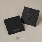 This custom black jewelry card features a rigid paperboard structure and precise cut-outs. It provides a professional display solution for jewelry.