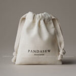 The pouch features a soft yet structured format that keeps jewelry protected during storage and transport. Its natural texture enhances visual warmth without overwhelming the overall presentation. The design remains understated, allowing the jewelry itself to remain the center of attention. This format is suitable for both daily retail use and e-commerce shipping environments.