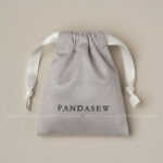 This custom faux sheepskin pouch features a soft suede texture and a vibrant finish. It provides an elegant storage solution for jewelry branding.