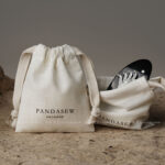 The pouch features a soft yet structured format that keeps jewelry protected during storage and transport. Its natural texture enhances visual warmth without overwhelming the overall presentation. The design remains understated, allowing the jewelry itself to remain the center of attention. This format is suitable for both daily retail use and e-commerce shipping environments.