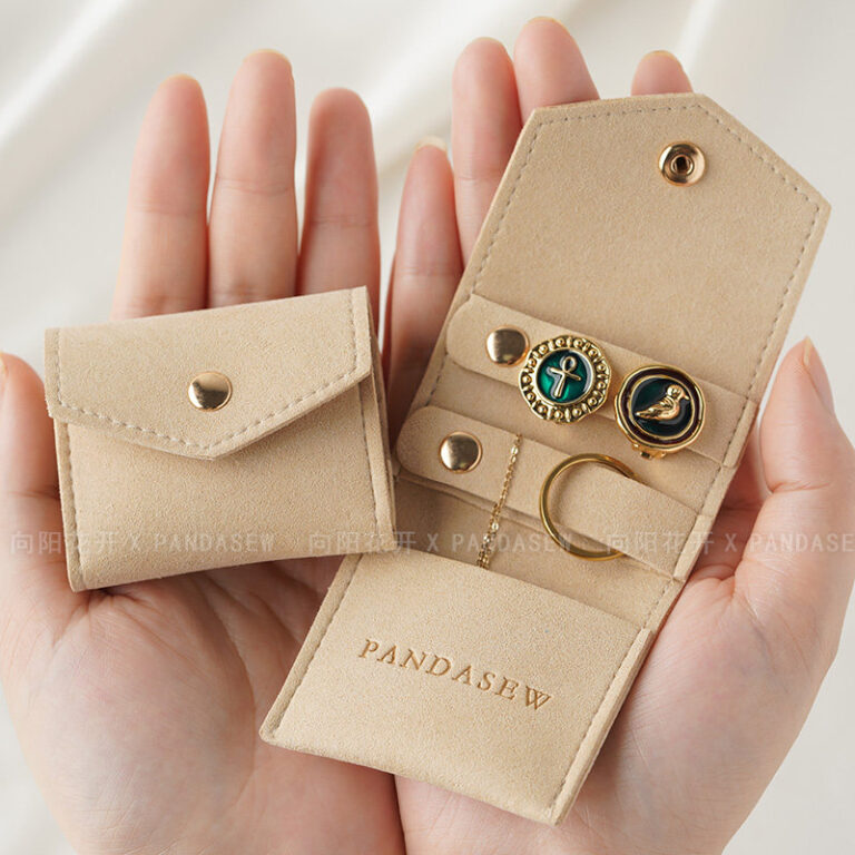 This custom folding jewelry pouch features a snap button and organized interior. It provides an elegant storage solution for jewelry branding.