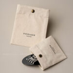 The design features a classic rectangular silhouette. It includes a reinforced snap button closure. Therefore, the jewelry stays in place without any risk of slipping out. The cotton canvas material is selected for its breathability. Additionally, the soft inner surface helps prevent scratches on delicate metal finishes. Its compact size makes it an ideal companion for travel. Moreover, it maintains a professional appearance that aligns with modern branding standards. The tactile experience of the canvas adds a layer of quality to your presentation.