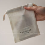 The pouch features a soft yet structured format that keeps jewelry protected during storage and transport. Its natural texture enhances visual warmth without overwhelming the overall presentation. The design remains understated, allowing the jewelry itself to remain the center of attention. This format is suitable for both daily retail use and e-commerce shipping environments.