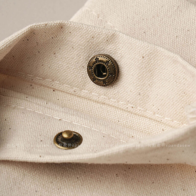 The design features a classic rectangular silhouette. It includes a reinforced snap button closure. Therefore, the jewelry stays in place without any risk of slipping out. The cotton canvas material is selected for its breathability. Additionally, the soft inner surface helps prevent scratches on delicate metal finishes. Its compact size makes it an ideal companion for travel. Moreover, it maintains a professional appearance that aligns with modern branding standards. The tactile experience of the canvas adds a layer of quality to your presentation.