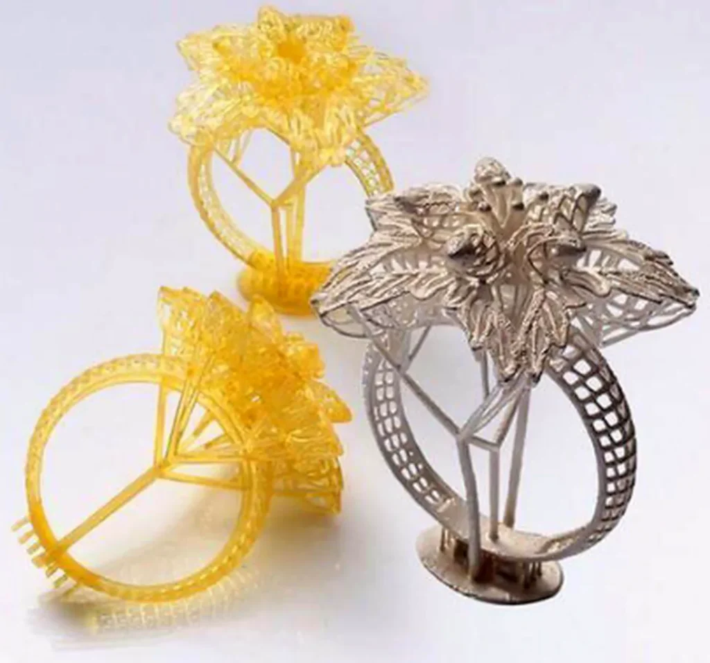 Yellow castable resin 3D-printed ring models next to the cast metal ring