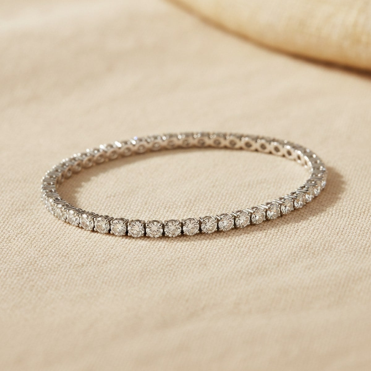 Classic white-gold diamond tennis bracelet on ivory linen — Alpha Jewelry