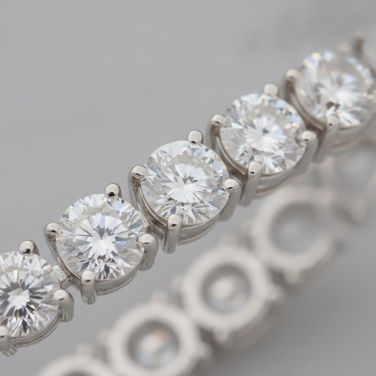 Macro of white-gold tennis bracelet prong settings — Alpha Jewelry