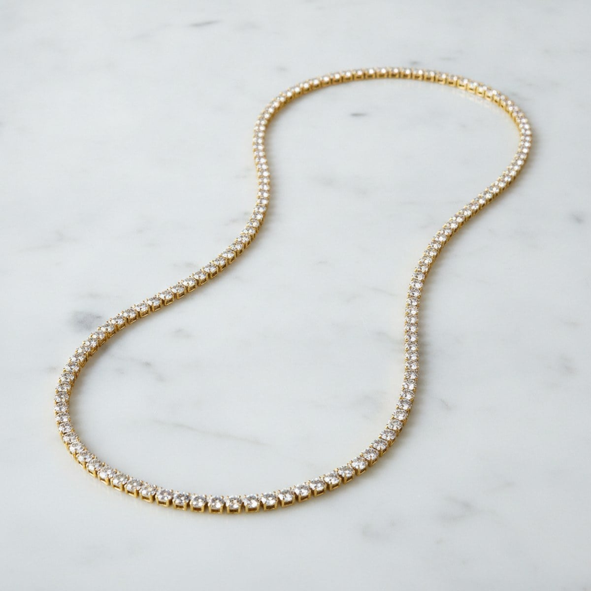 Yellow-gold diamond tennis necklace on marble — Alpha Jewelry OEM